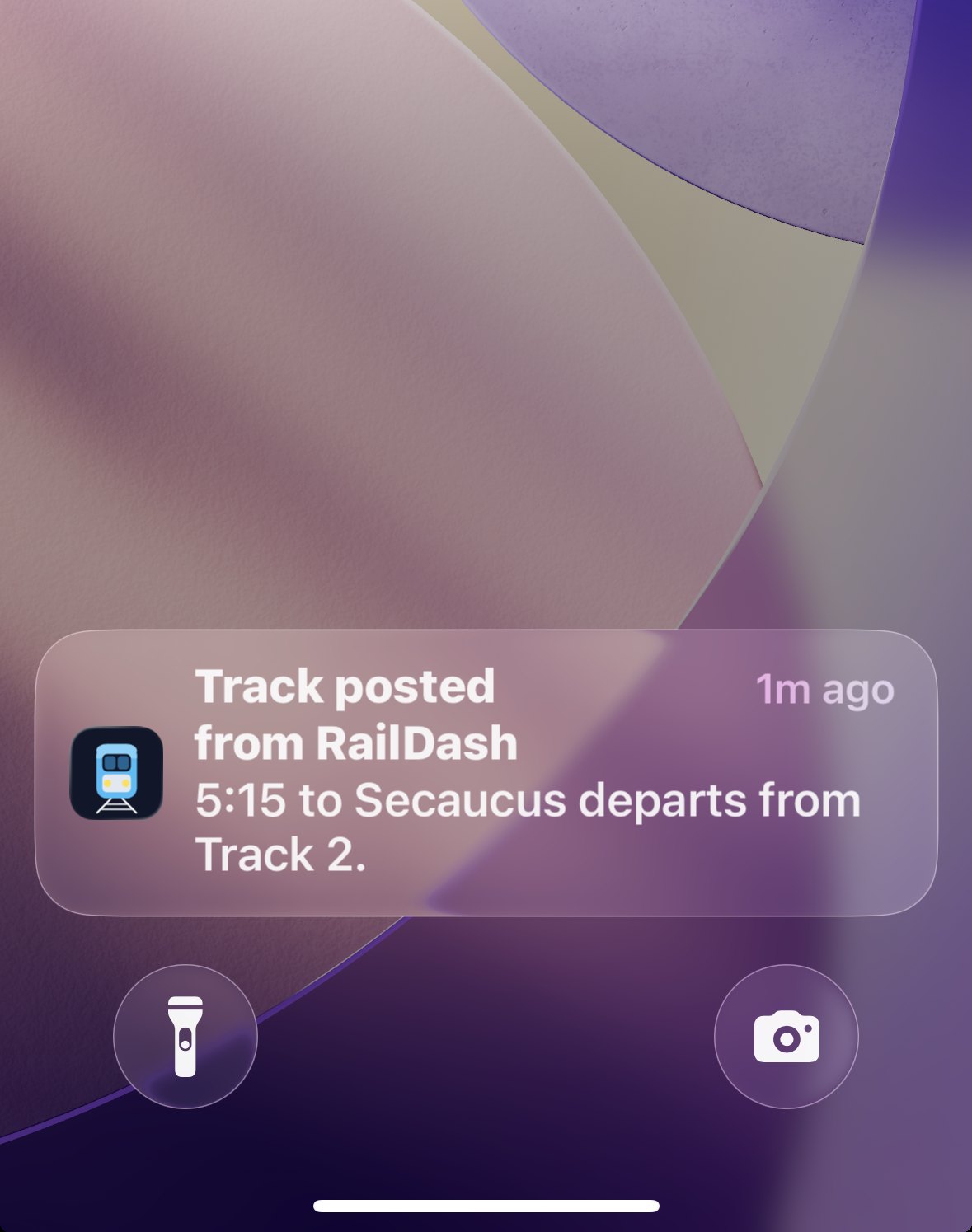 An iPhone lock screen showing a RailDash push: Track posted — 5:15 to Secaucus departs from Track 2